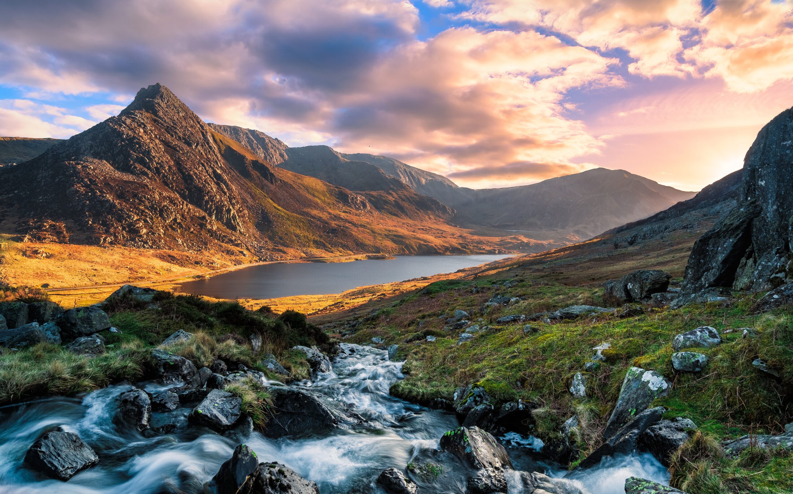 Mountain landscape in Snowdonia with lake and stream at sunset in North Wales