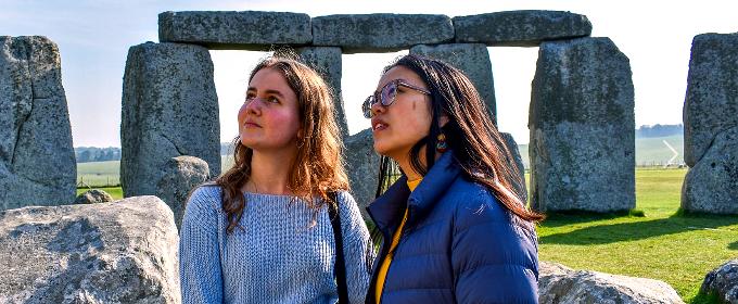 Visitors inside Stonehenge Inner Circle standing close to the stones during special access tour